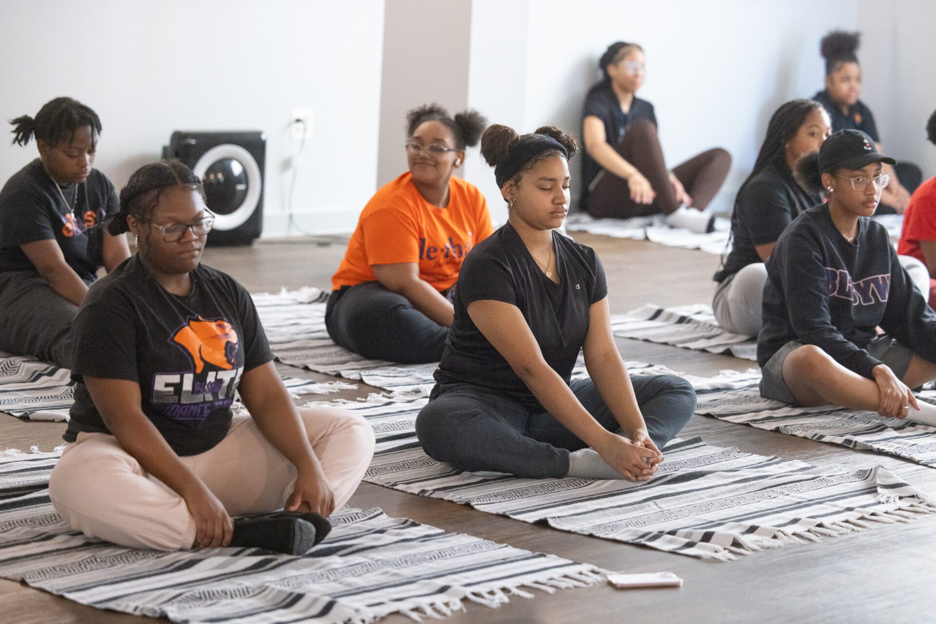 Teacher in patterned dress gesturing during a class.
